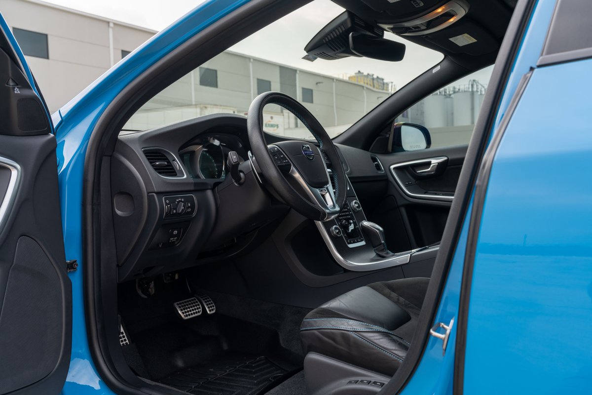 Interior of a Rebel Blue 2015 Volvo V60 Polestar showing the driver's seat, dashboard and steering wheel.