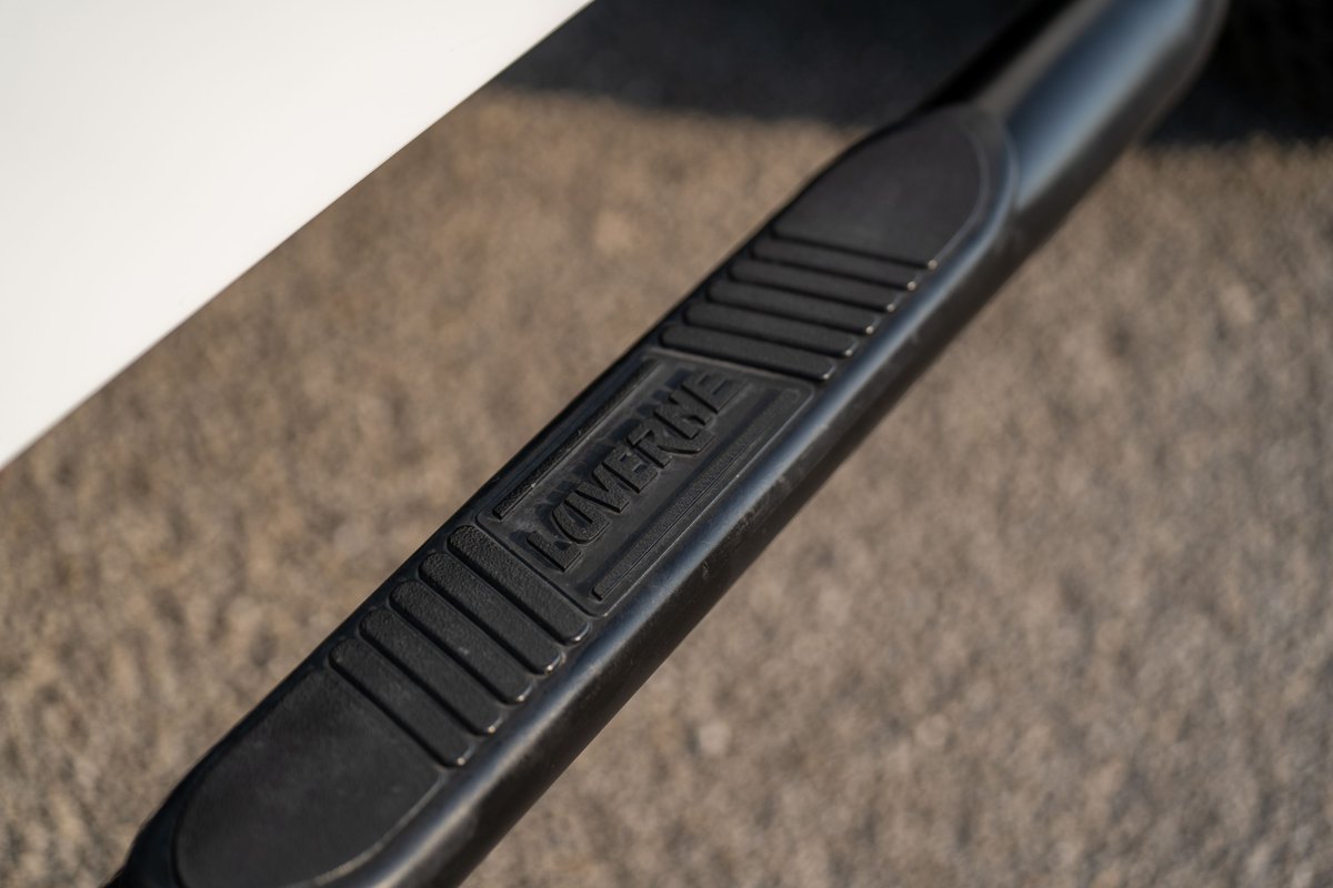 Black step bar with "LOVERNE" embossed logo on a white 1983 Jeep Scrambler.