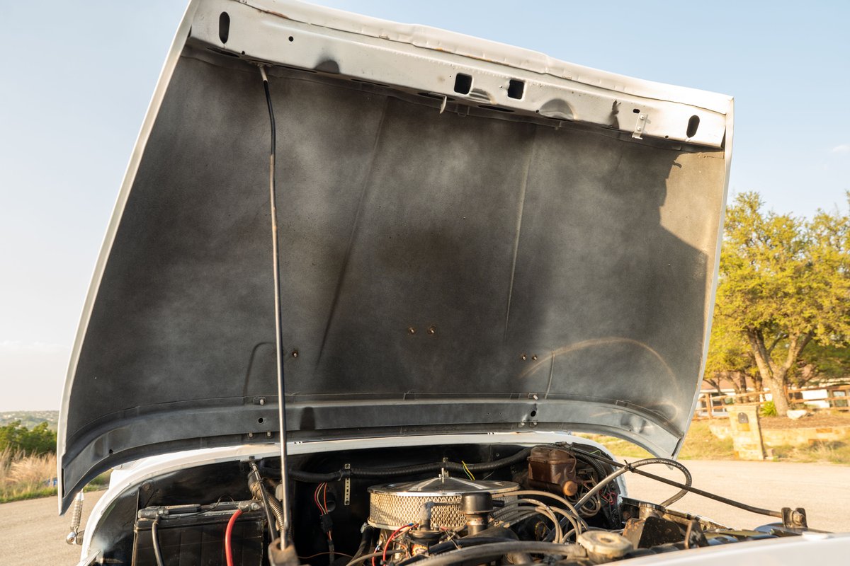 1983 white Jeep Scrambler engine bay, hood open, with chrome air cleaner.