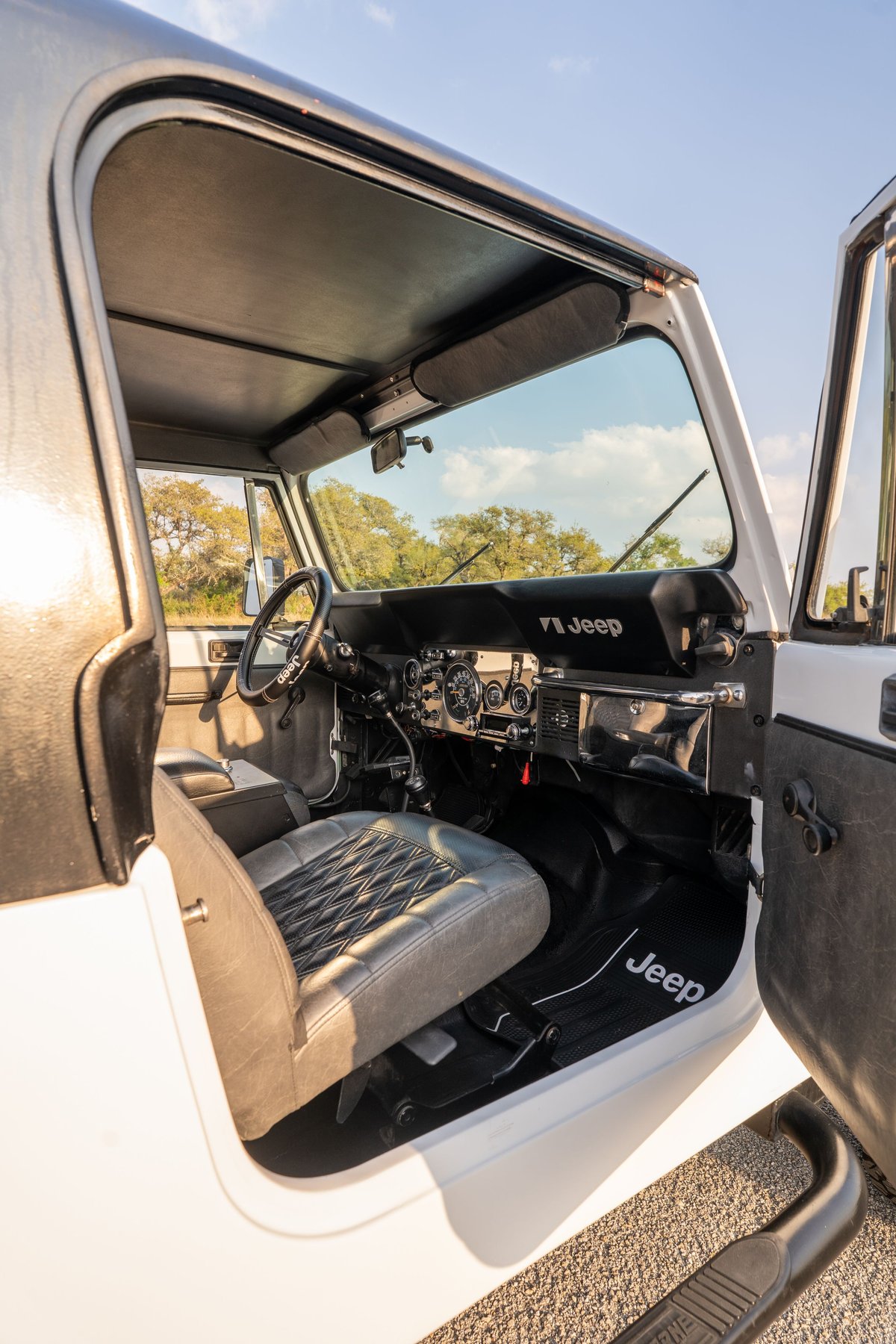 1983 Jeep Scrambler interior view, showing diamond-stitched seats and dashboard details.