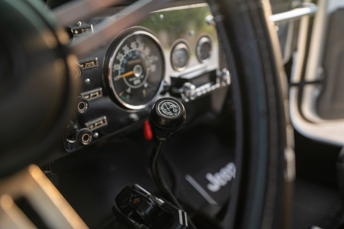 1983 Jeep Scrambler interior with 4x4 transfer case shifter and vintage gauge cluster.
