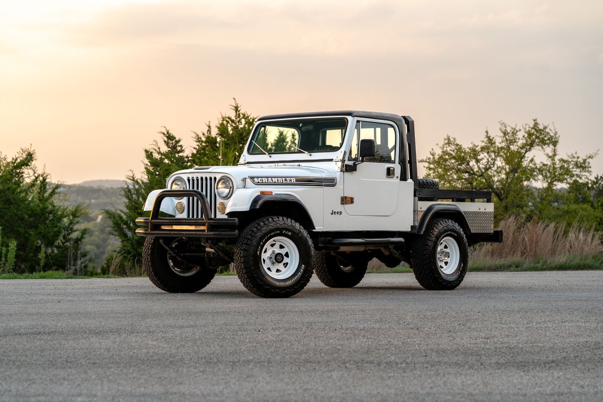 1983 Jeep Scrambler pickup truck with a white exterior, black trim, and white rims.
