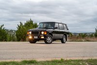 1994 Land Rover Range Rover County LWB in black, featuring classic quad headlights and 5-spoke rims.