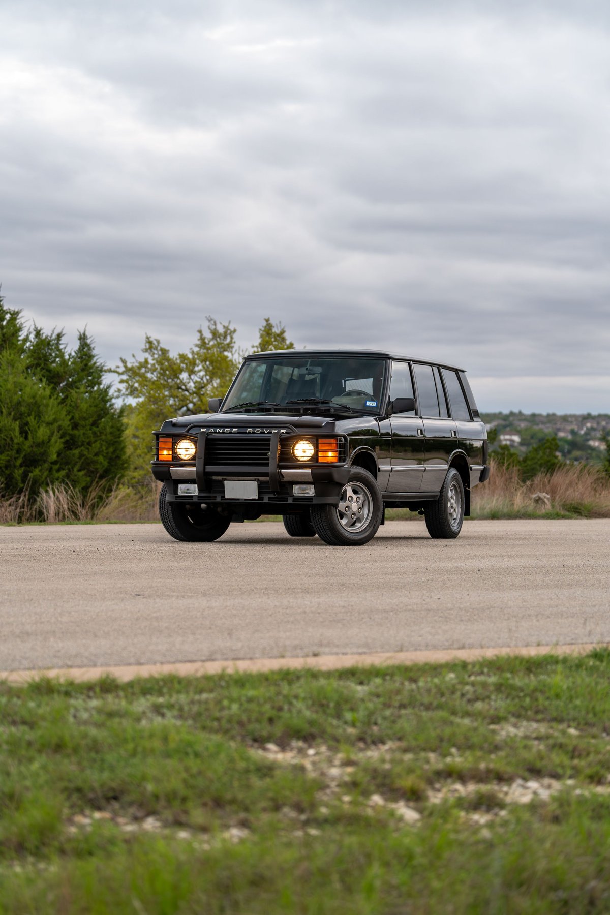 Black 1994 Range Rover County LWB on road with chrome trim and alloy rims.