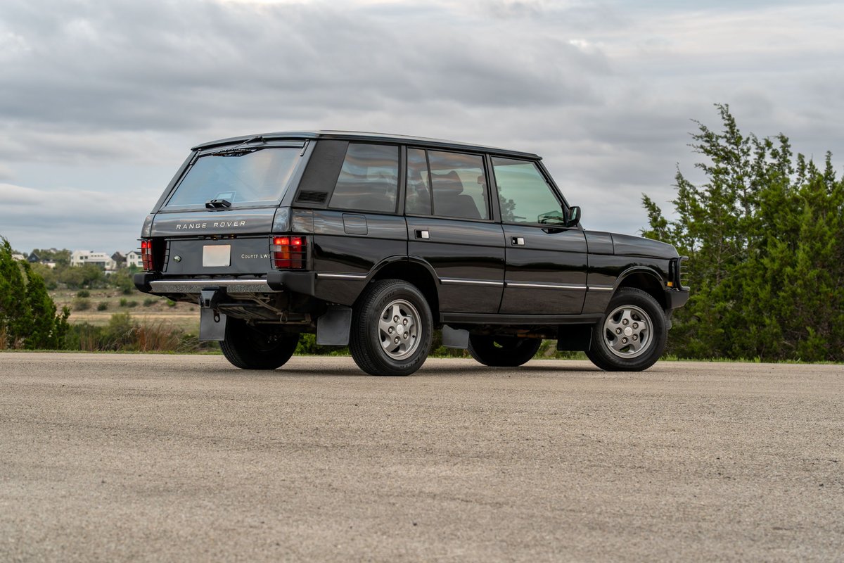 Rear 3/4 view of a black 1994 Range Rover County LWB with chrome trim and alloy rims.