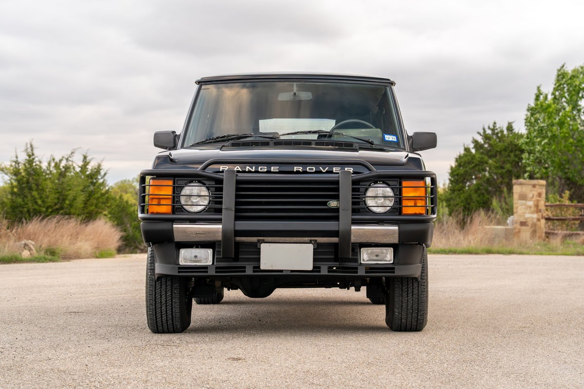 Front view of a black 1994 Land Rover Range Rover County LWB with a brush guard and alloy rims.