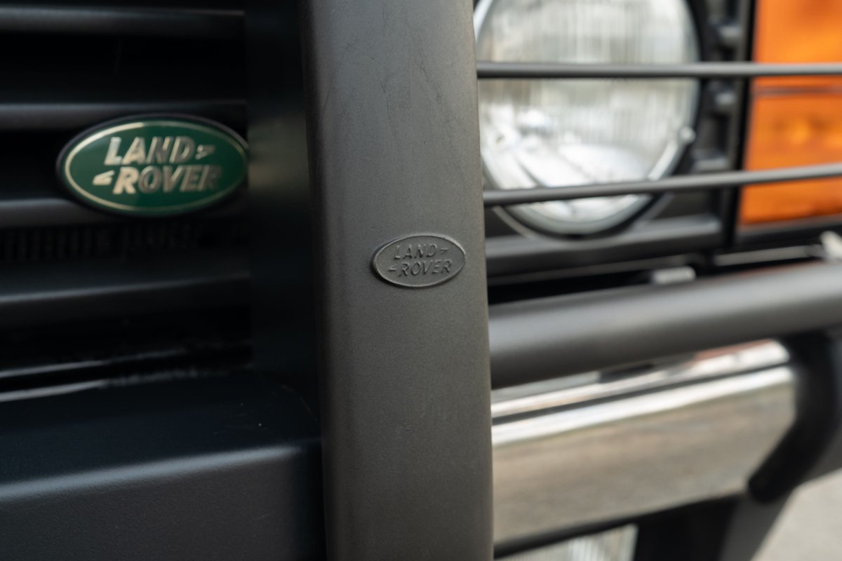 Close-up of a 1994 Land Rover Range Rover County LWB's black brush guard with Land Rover emblems and headlights.