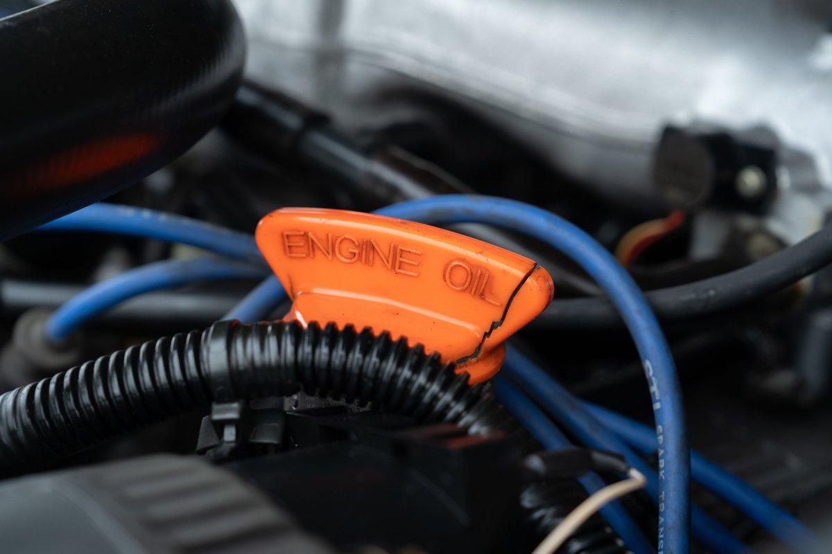 Orange engine oil cap with "ENGINE OIL" text on a 1994 Land Rover Range Rover County LWB.