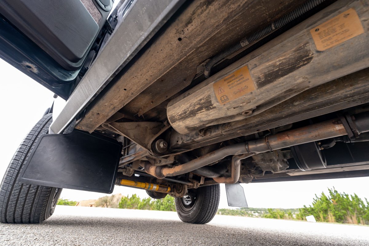 Underside view of a 1994 Range Rover County LWB with mud flaps and exhaust system.
