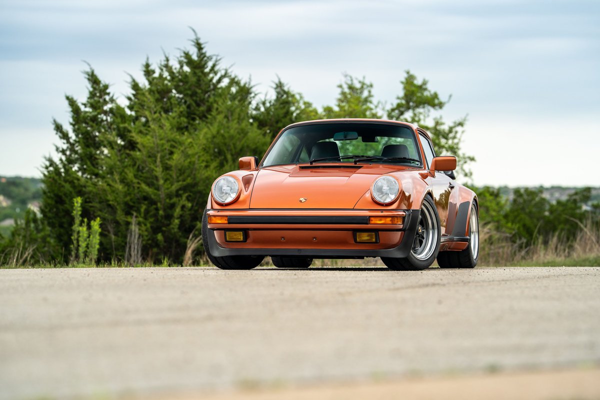 Orange metallic 1986 Porsche 930 Turbo with black trim and chrome rims.