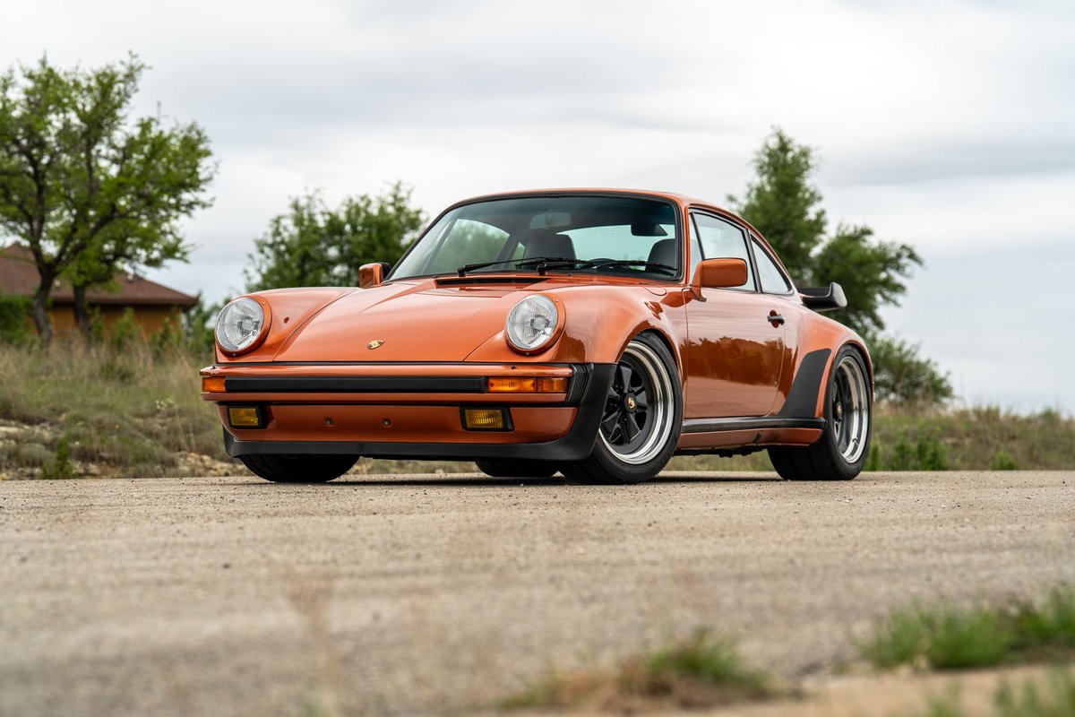 Orange metallic 1986 Porsche 930 Turbo with Fuchs rims and wide body trim.