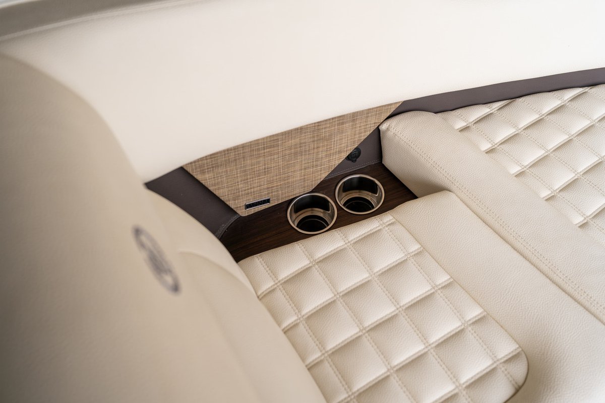 Cobalt R7 Surf boat interior features diamond-stitched cream upholstery and built-in cup holders.
