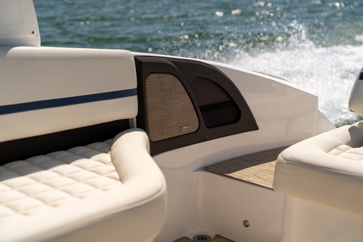 Interior of a 2025 Cobalt R7 Surf boat with white quilted upholstery and dark trim.