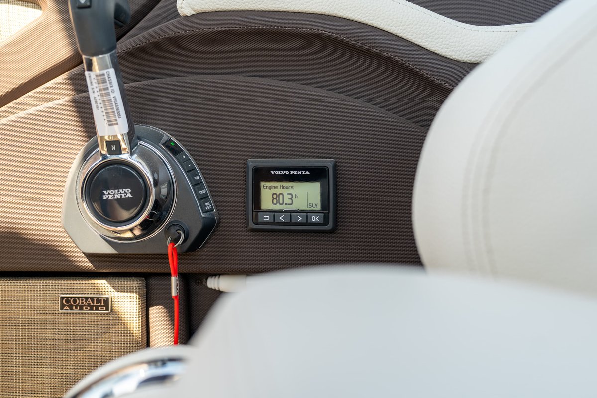 Close-up of Cobalt R7 Surf boat's helm: Volvo Penta throttle, digital display, and Cobalt Audio speaker.