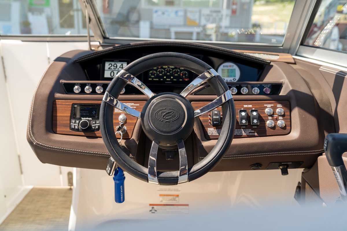 Cobalt R7 Surf boat helm with woodgrain trim, chrome steering wheel, and digital dash.