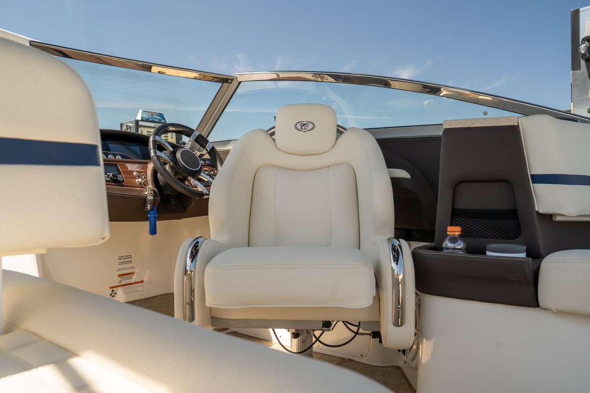 Interior of a white Cobalt R7 Surf boat with tan leather seating and chrome accents.