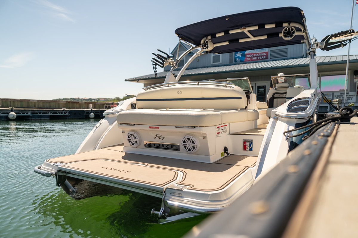 Rear view of a white 2018 Cobalt R7 Surf boat with speakers and a sundeck.