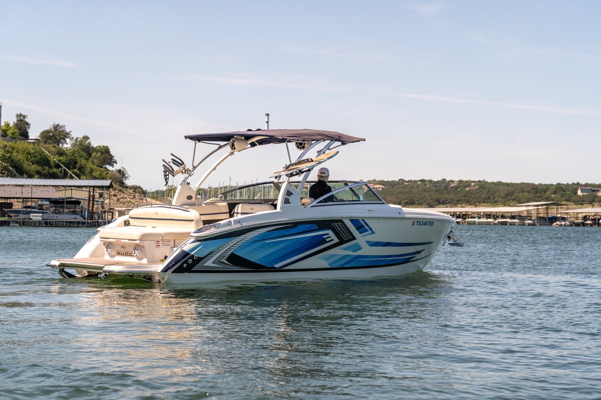 2018 Cobalt R7 Surf boat with a blue and white livery, navigating on the water.