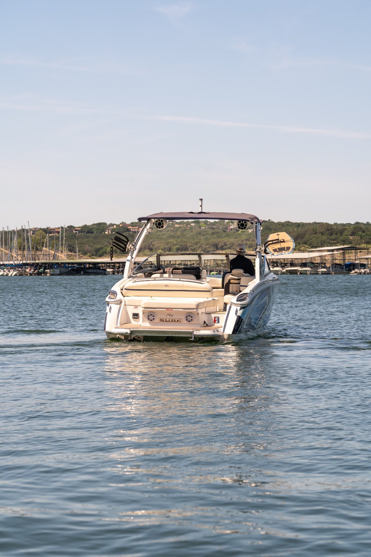 2025 Cobalt R7 Surf wake boat with blue accents and a silver hull, navigating calm waters.