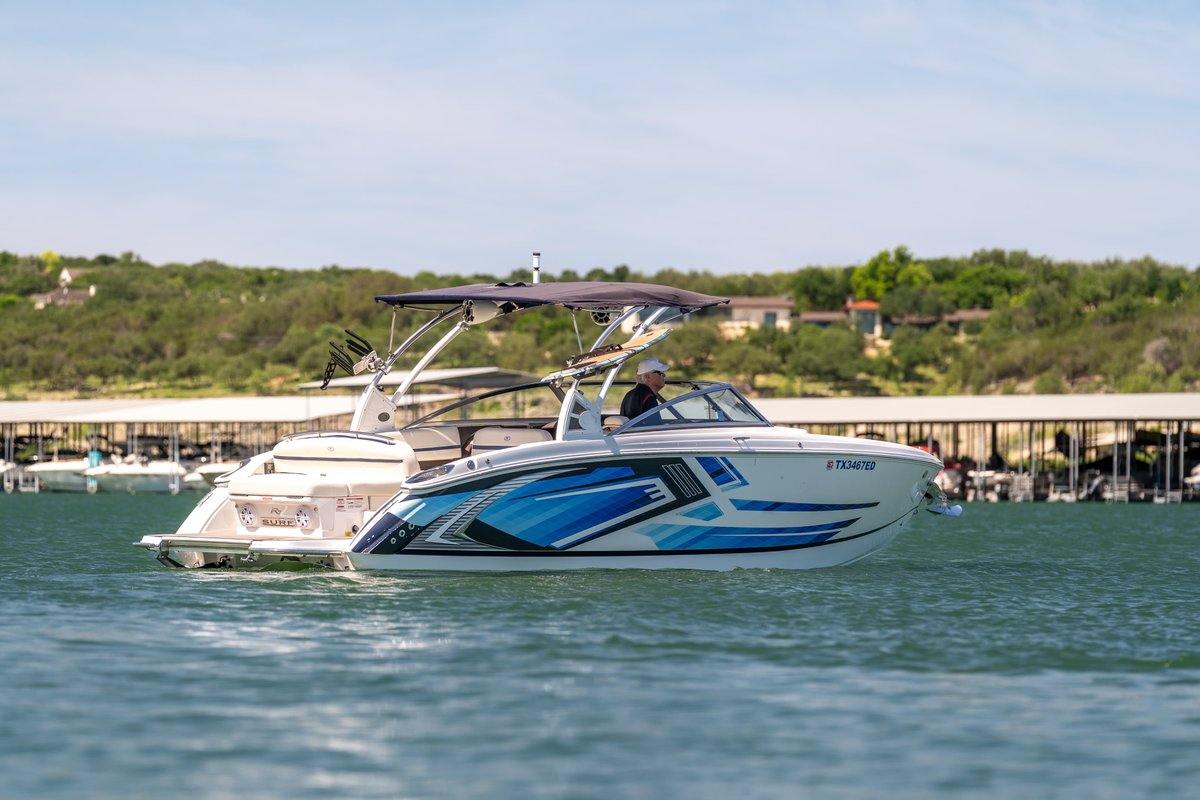 Cobalt R7 Surf boat with blue and white graphic livery, on a lake.
