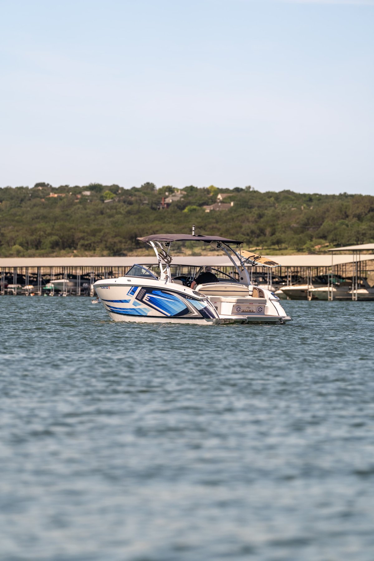 2025 Cobalt R7 Surf boat with a blue and white hull livery, on the water.