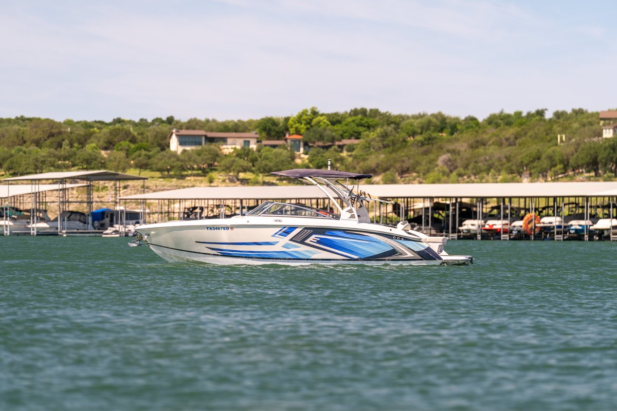 Cobalt R7 Surf boat with blue and white livery, white hull, and tower.