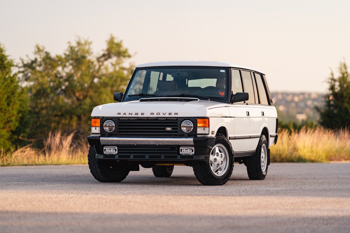White 1995 Range Rover County with chrome trim and alloy rims parked outdoors.