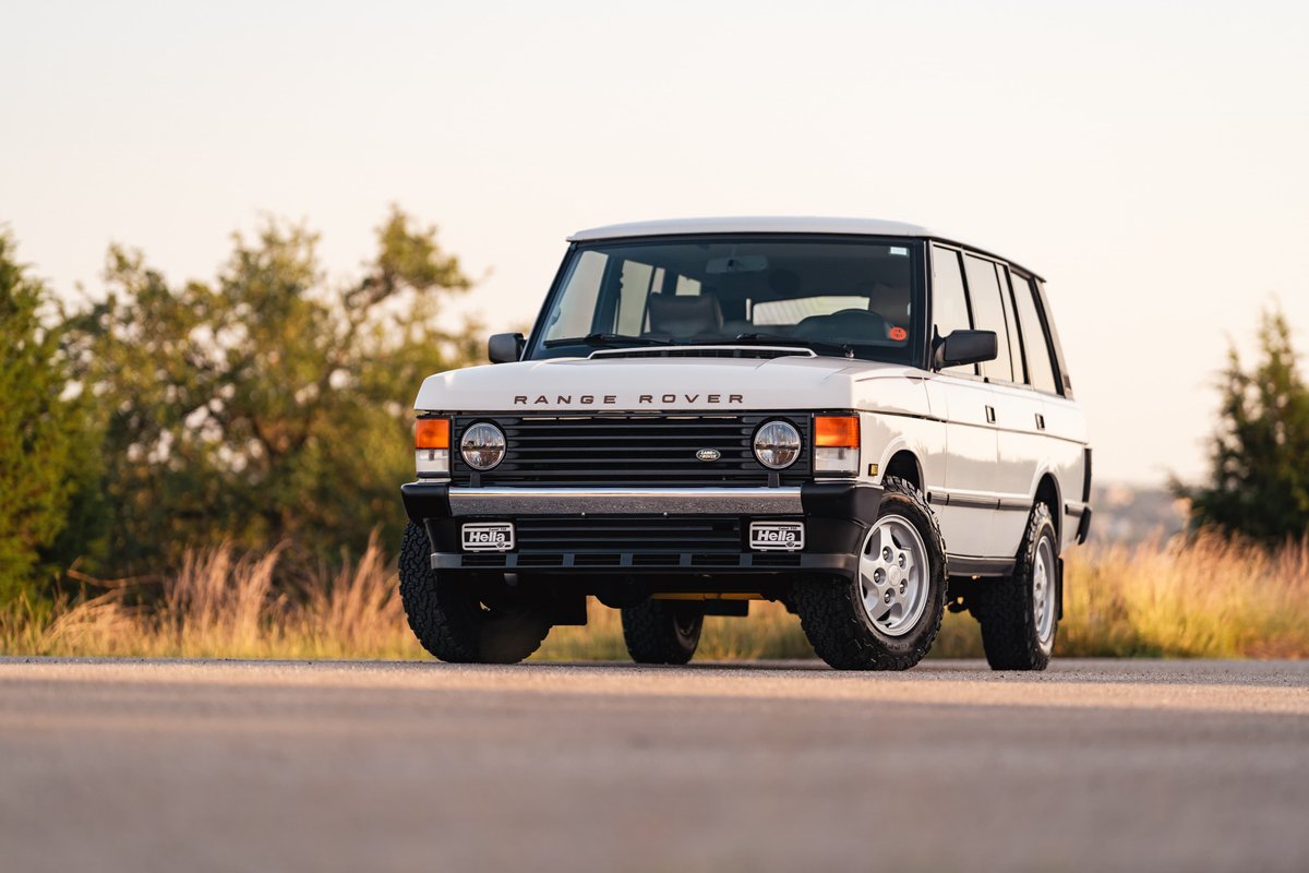 1995 Range Rover County in white, featuring chrome grille and 5-spoke alloy rims.