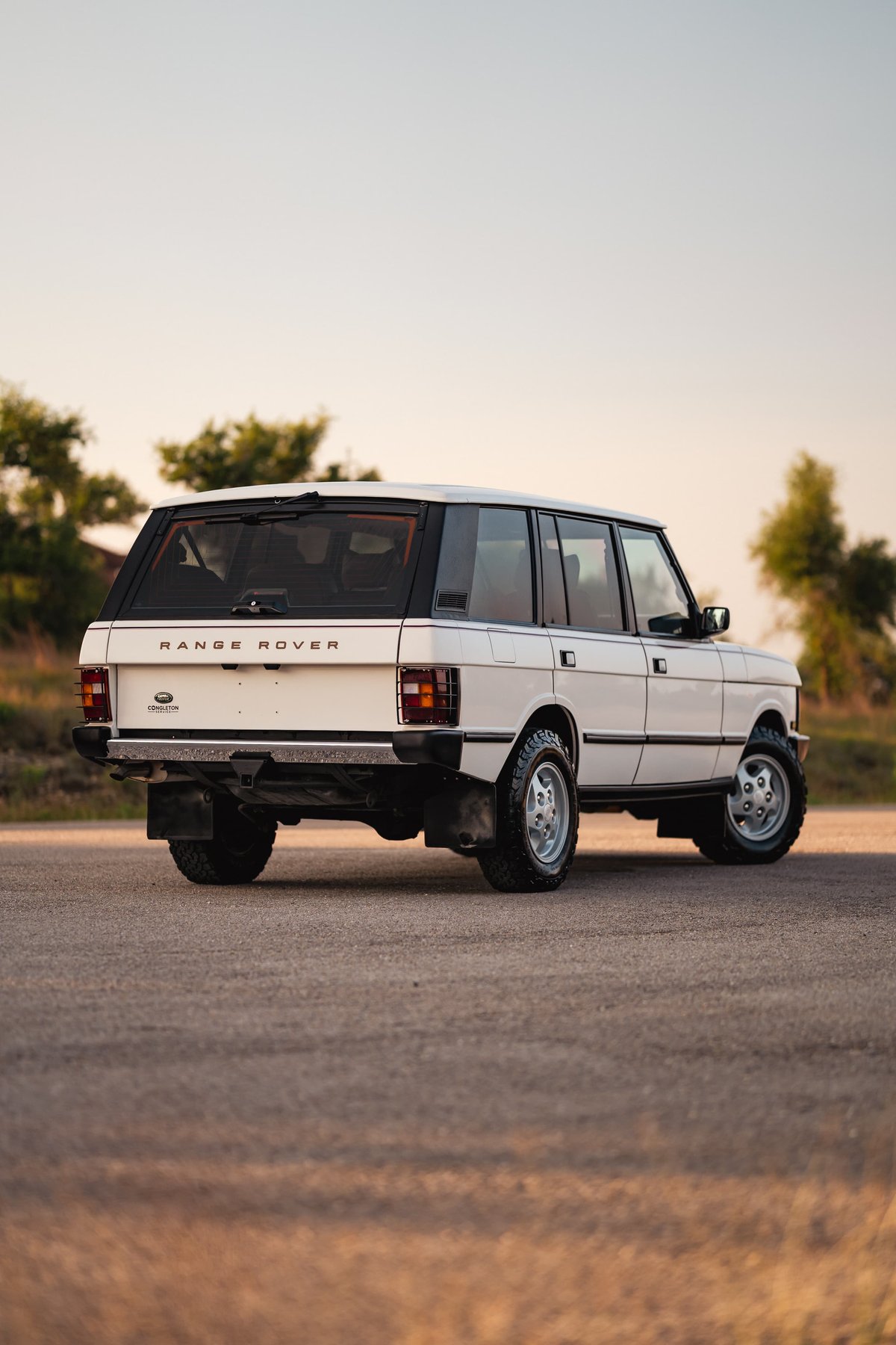 Rear view of a white 1995 Land Rover Range Rover County with silver rims and chrome trim.