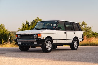 White 1995 Range Rover County edition with chrome accents and classic alloy rims.