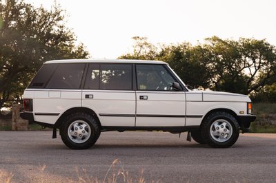 Side profile of a white 1995 Land Rover Range Rover County with silver five-spoke rims.
