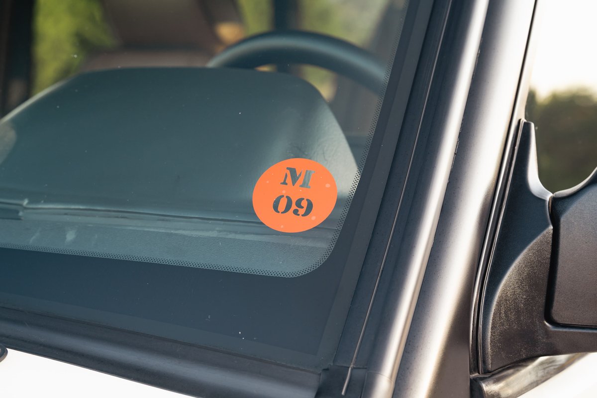 Orange inspection sticker with M 09 on the windshield of a white 1995 Land Rover Range Rover County.