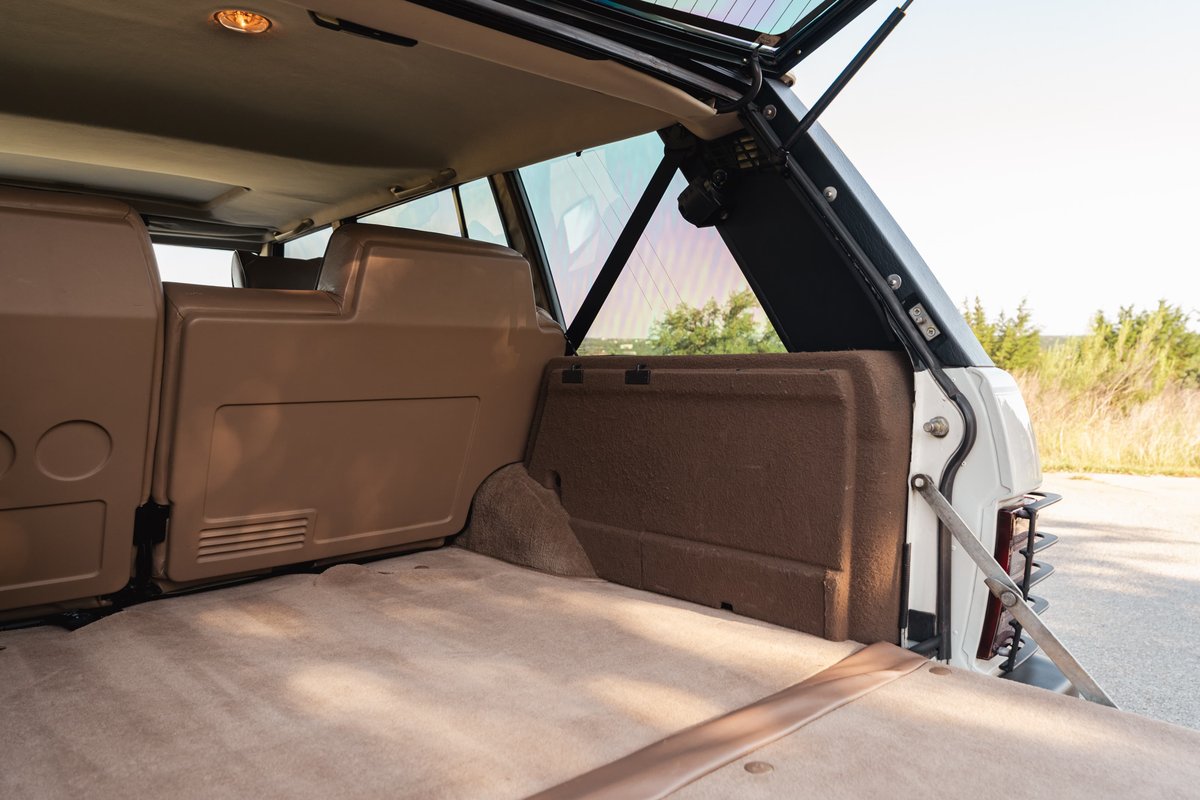 1995 Land Rover Range Rover County: tan carpeted cargo area with brown trim and open tailgate.