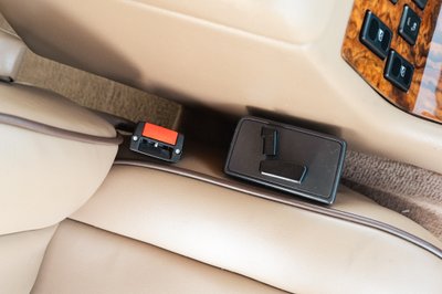 1995 white Land Rover Range Rover County seatbelt buckle and seat control panel.