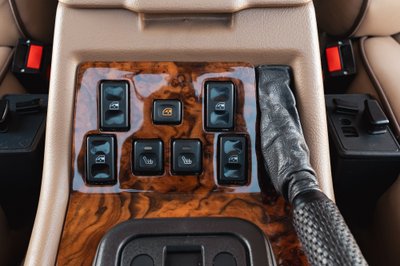 1995 Land Rover Range Rover County interior: wood trim, window and heated seat controls, leather gear shifter.