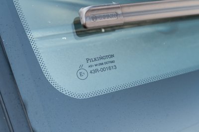 White 1995 Land Rover Range Rover windshield glass with Pilkington markings and Bosch wiper.