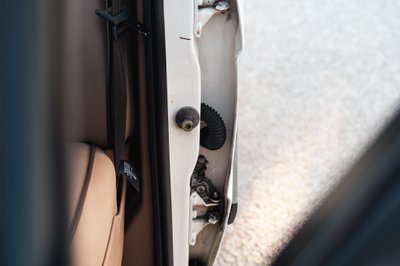 White 1995 Land Rover Range Rover County door latch mechanism and interior trim.