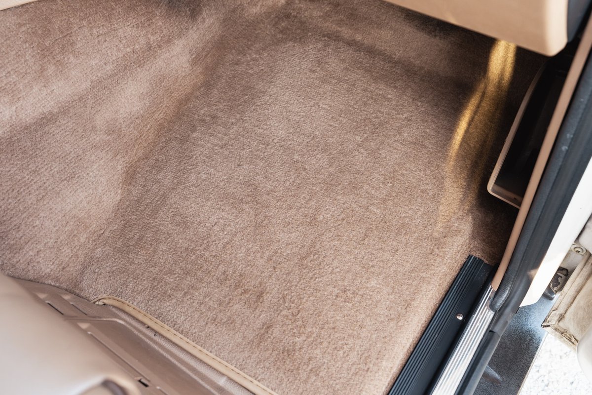 Tan carpet and trim on the floor of a white 1995 Land Rover Range Rover County.