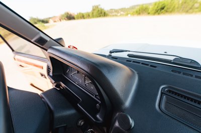 Interior view of a white 1995 Land Rover Range Rover County dashboard with analog gauges and wood trim.