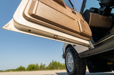 1995 white Land Rover Range Rover County door open, showing tan trim and wheel.