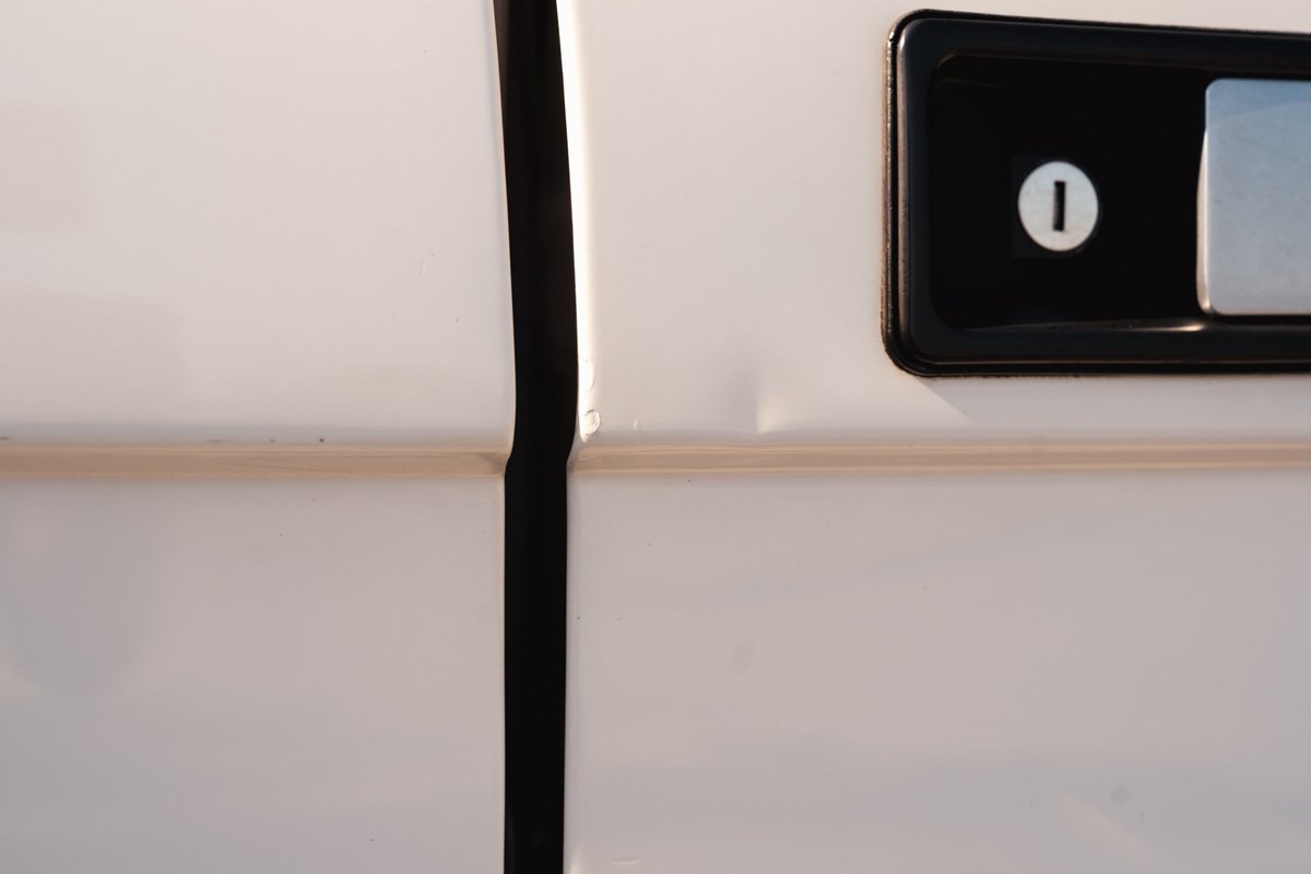 White 1995 Range Rover County door trim detail with black door handle and lock cylinder.