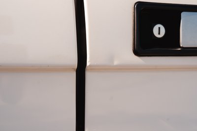 White 1995 Range Rover County door trim detail with black door handle and lock cylinder.