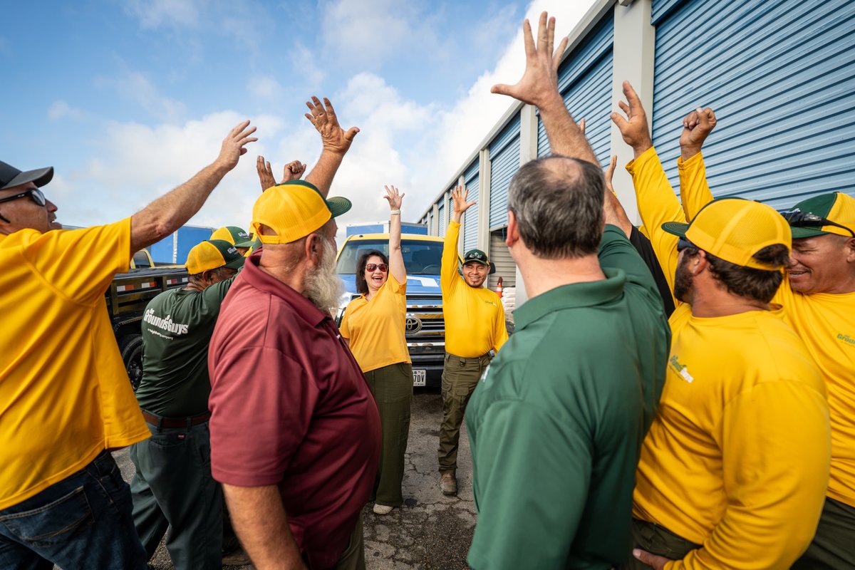 Blue truck, part of a commercial shoot, with multiple men in yellow and green shirts celebrating.