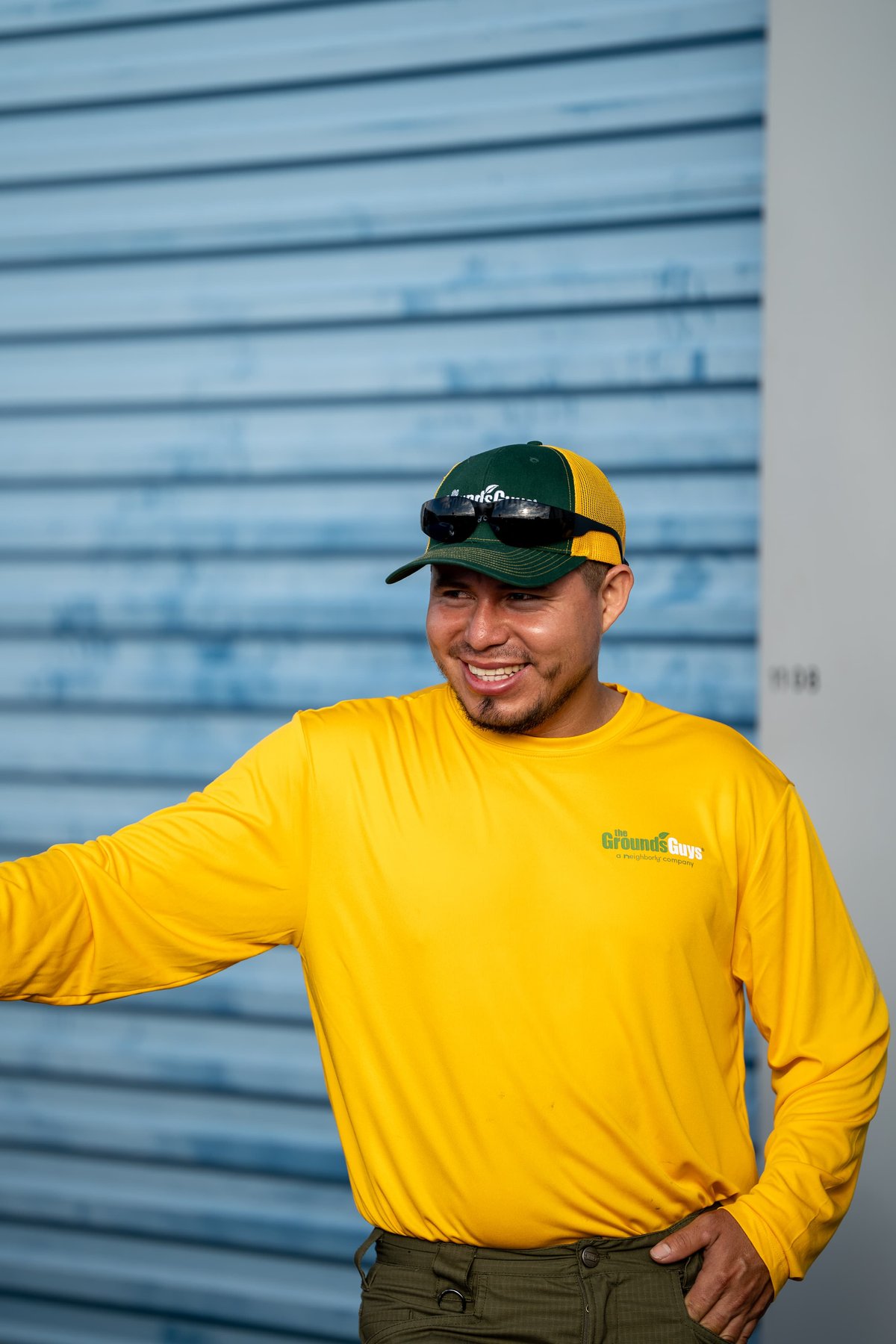 There is no car in this image. The image shows a man wearing a yellow shirt and a green and yellow cap.
