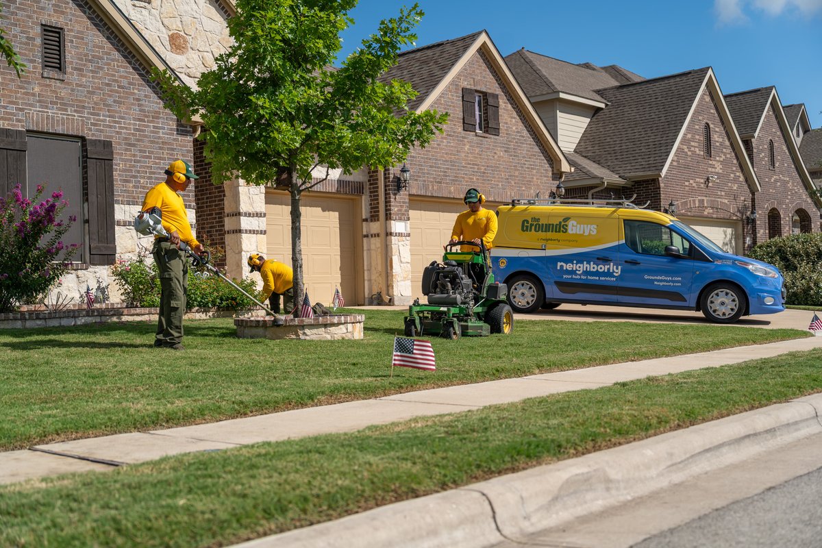 Ford Transit Connect van with "The Grounds Guys" livery, blue body with yellow roof.