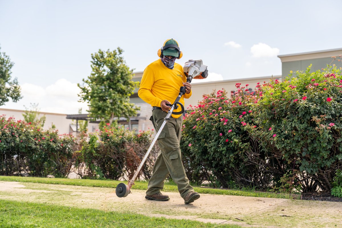 I am sorry, but there is no vehicle in this image. The image shows a person using a string trimmer.