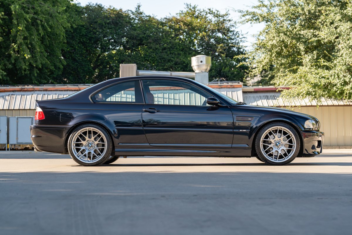 2002 BMW M3 coupe in Carbon Black, featuring chrome multi-spoke rims and M trim.