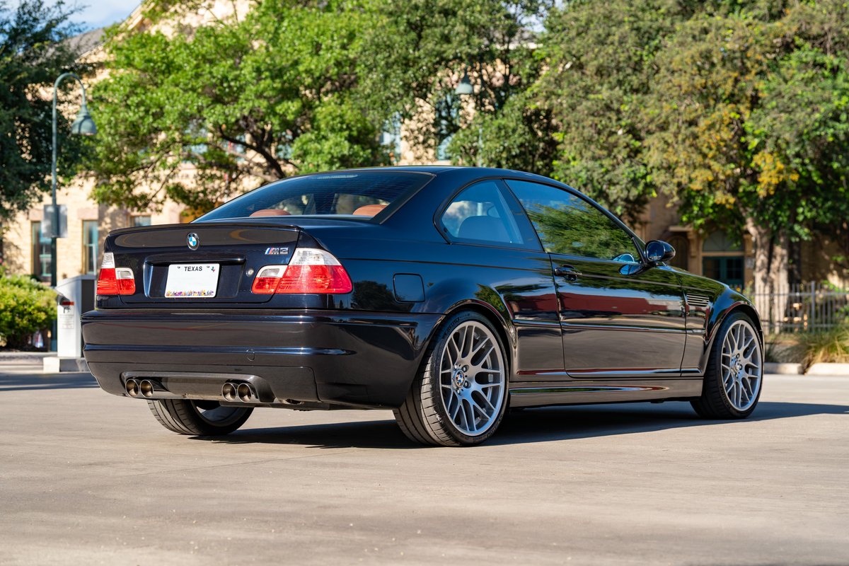 Rear quarter view of a black 2002 BMW M3 coupe with silver multi-spoke rims.