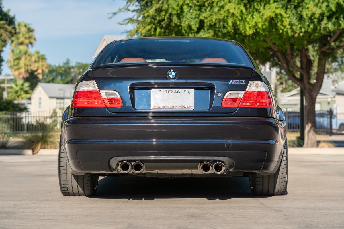 Black 2002 BMW M3 E46 rear view. Features quad exhaust tips and M3 badging.