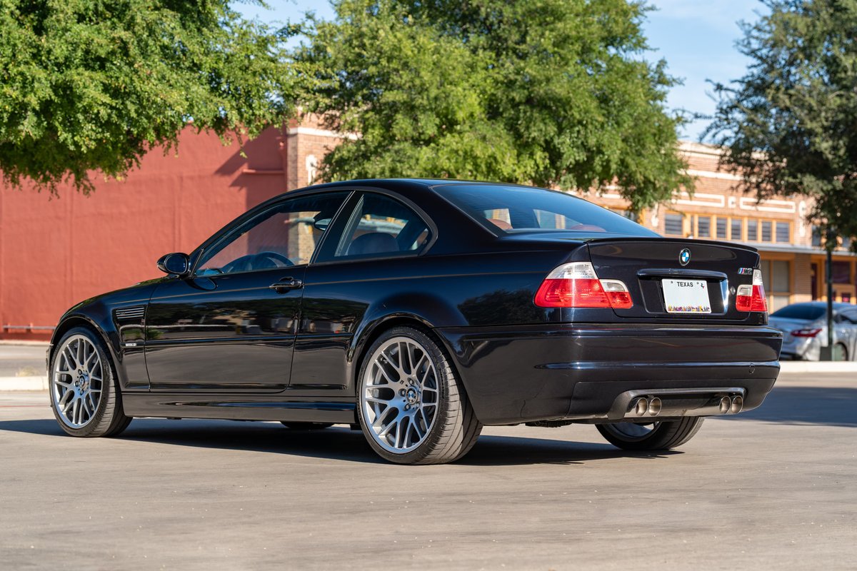 Black 2002 BMW M3 coupe with silver CSL rims and quad exhaust.